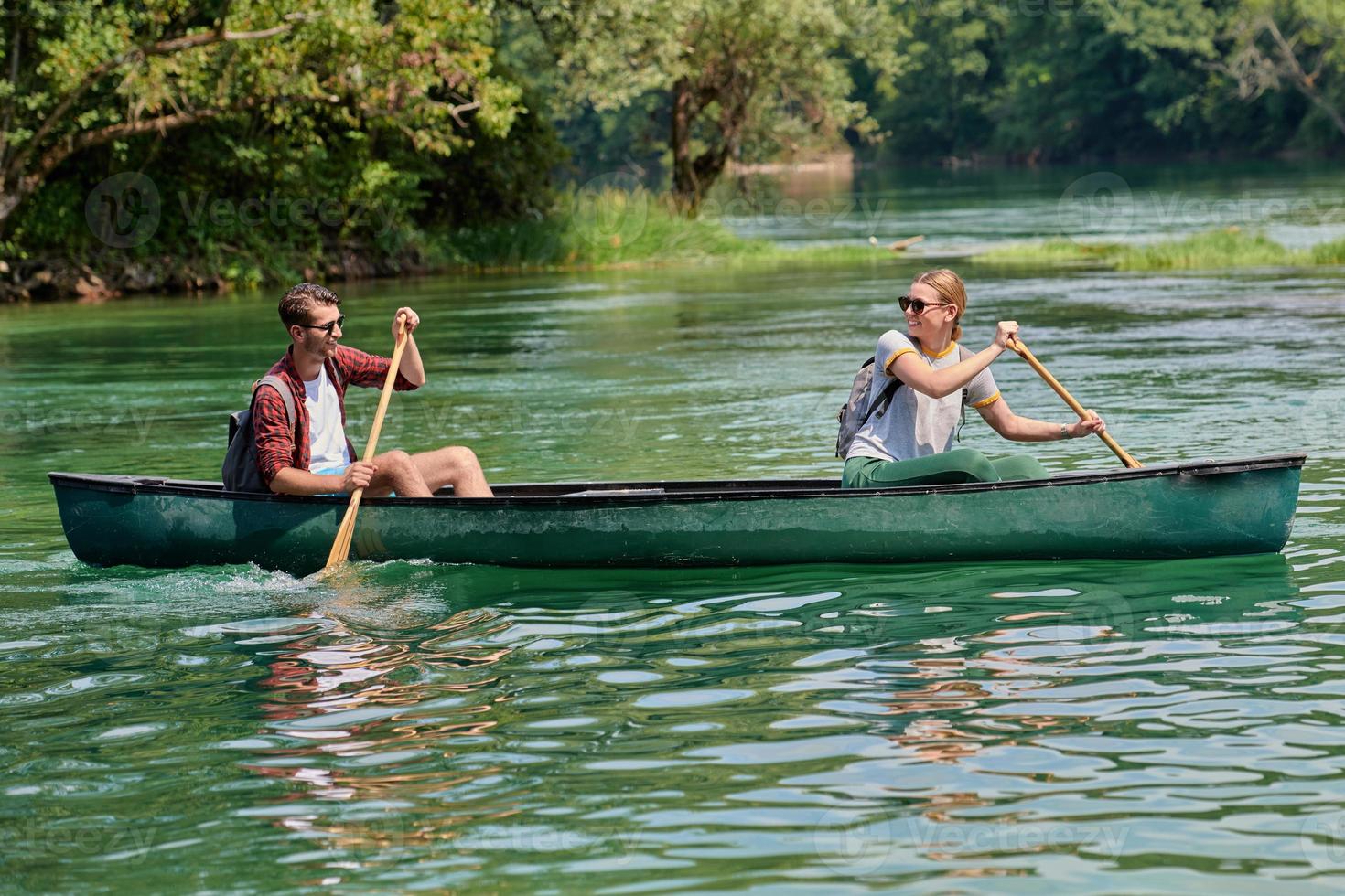 friends are canoeing in a wild river photo