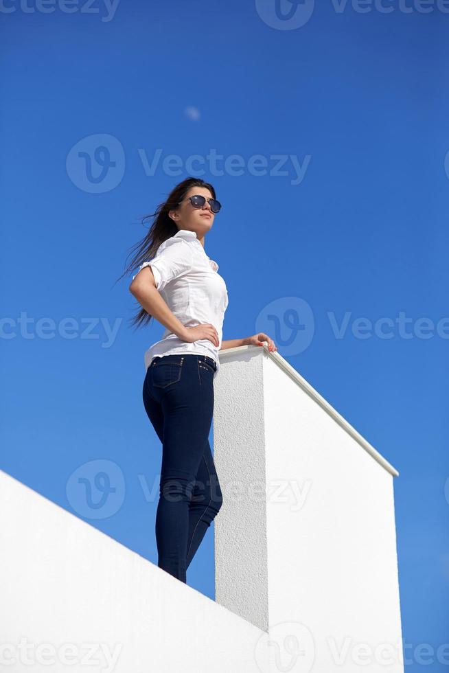 relaxed woman in front of luxury modern home photo