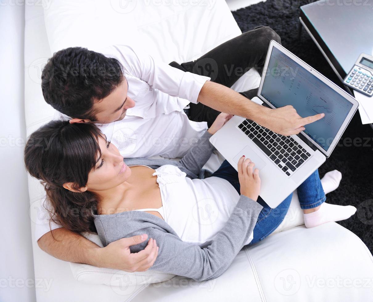 joyful couple relax and work on laptop computer at modern home photo