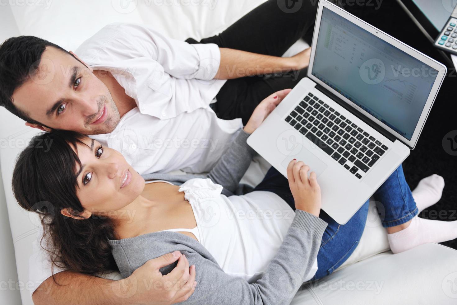 joyful couple relax and work on laptop computer at modern home photo