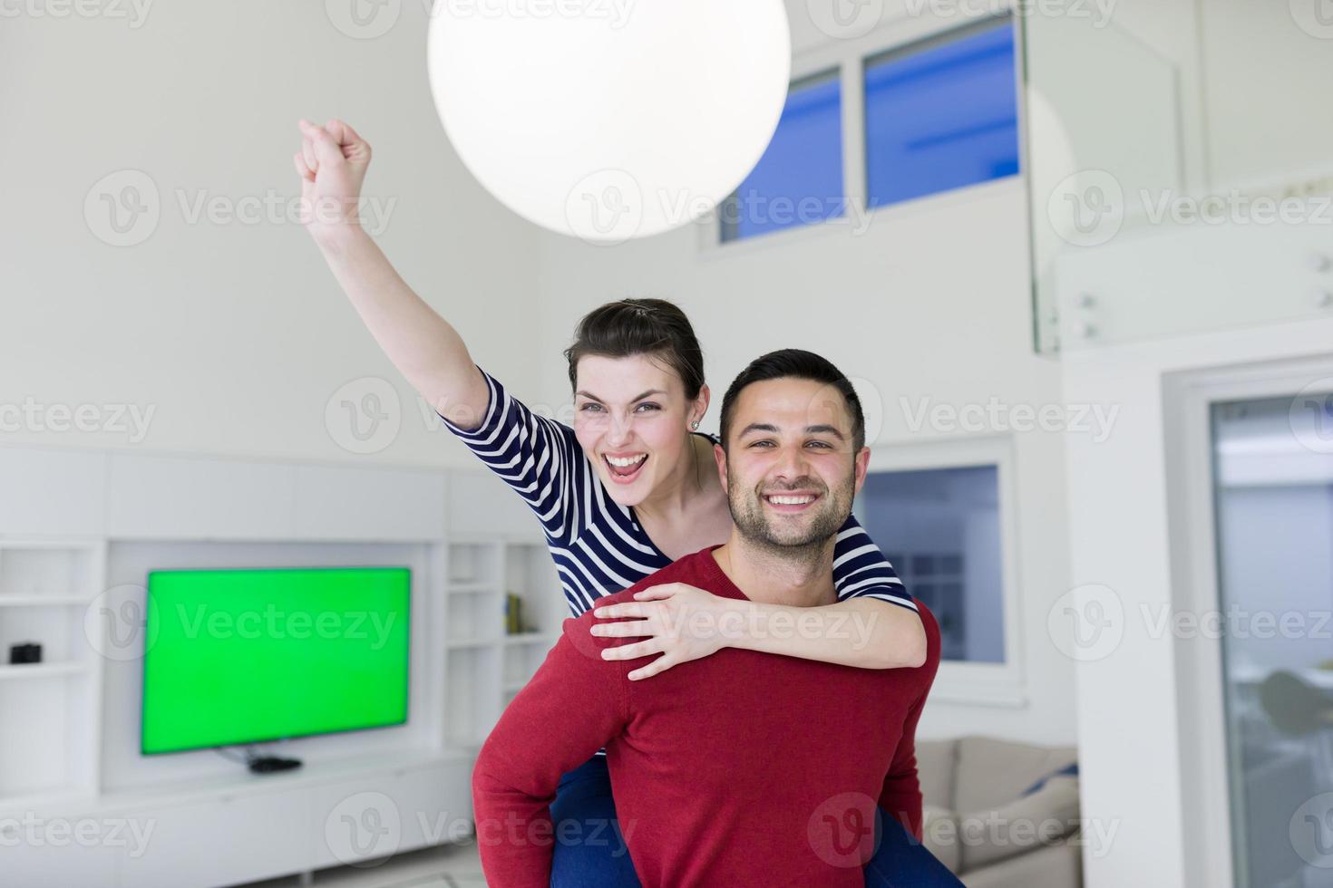 handsome man piggybacking his girlfriend photo