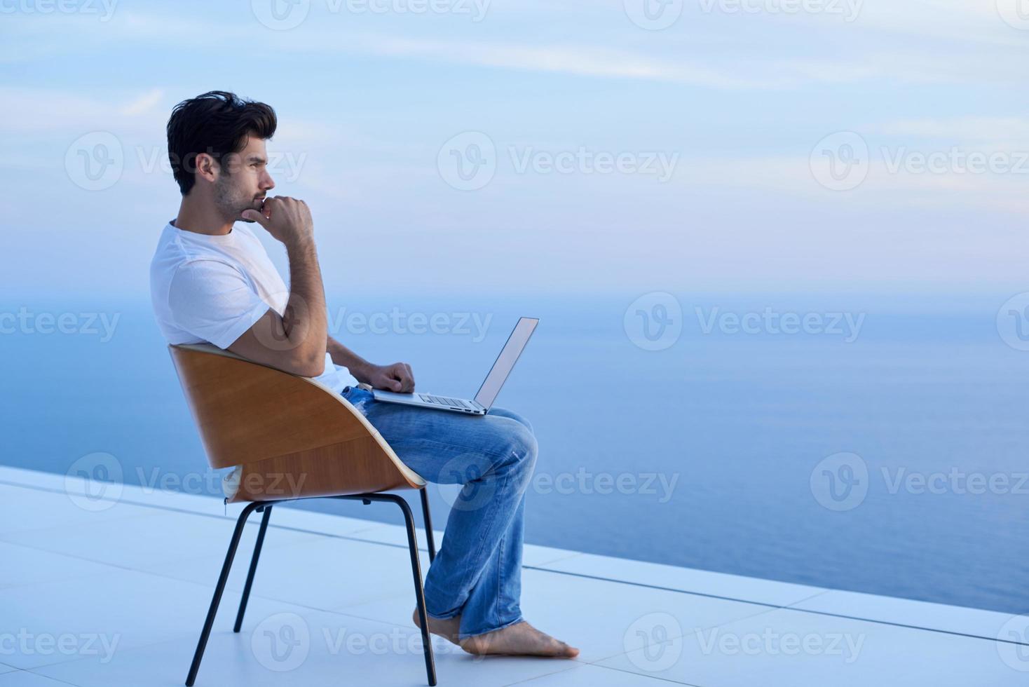 relaxed young man at home on balcony photo