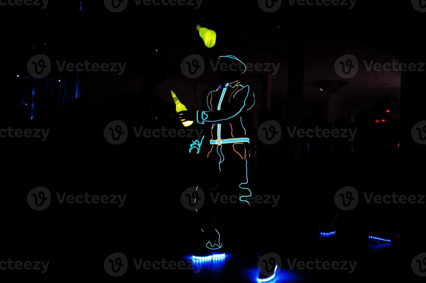 Professional barman and led light show. Silhouette of modern bartender shaking drink at night cocktail bar. photo