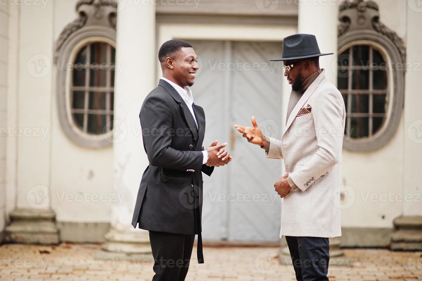 Two fashion black men. Fashionable portrait of african american male models. Wear suit, coat and hat. photo