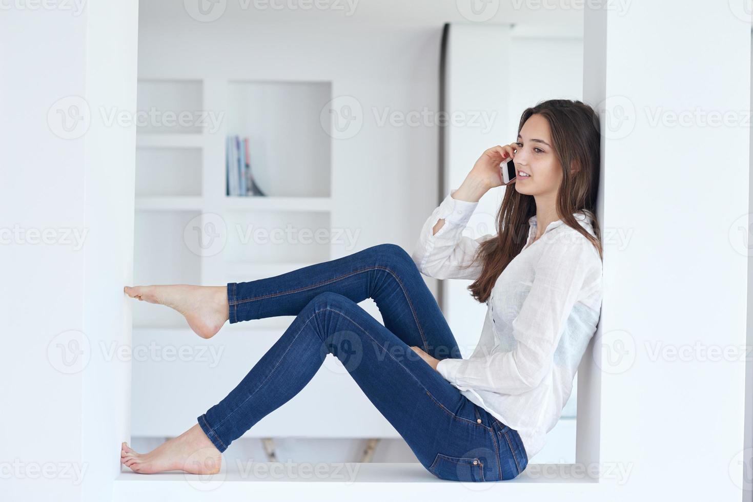 young woman using cellphone at home photo