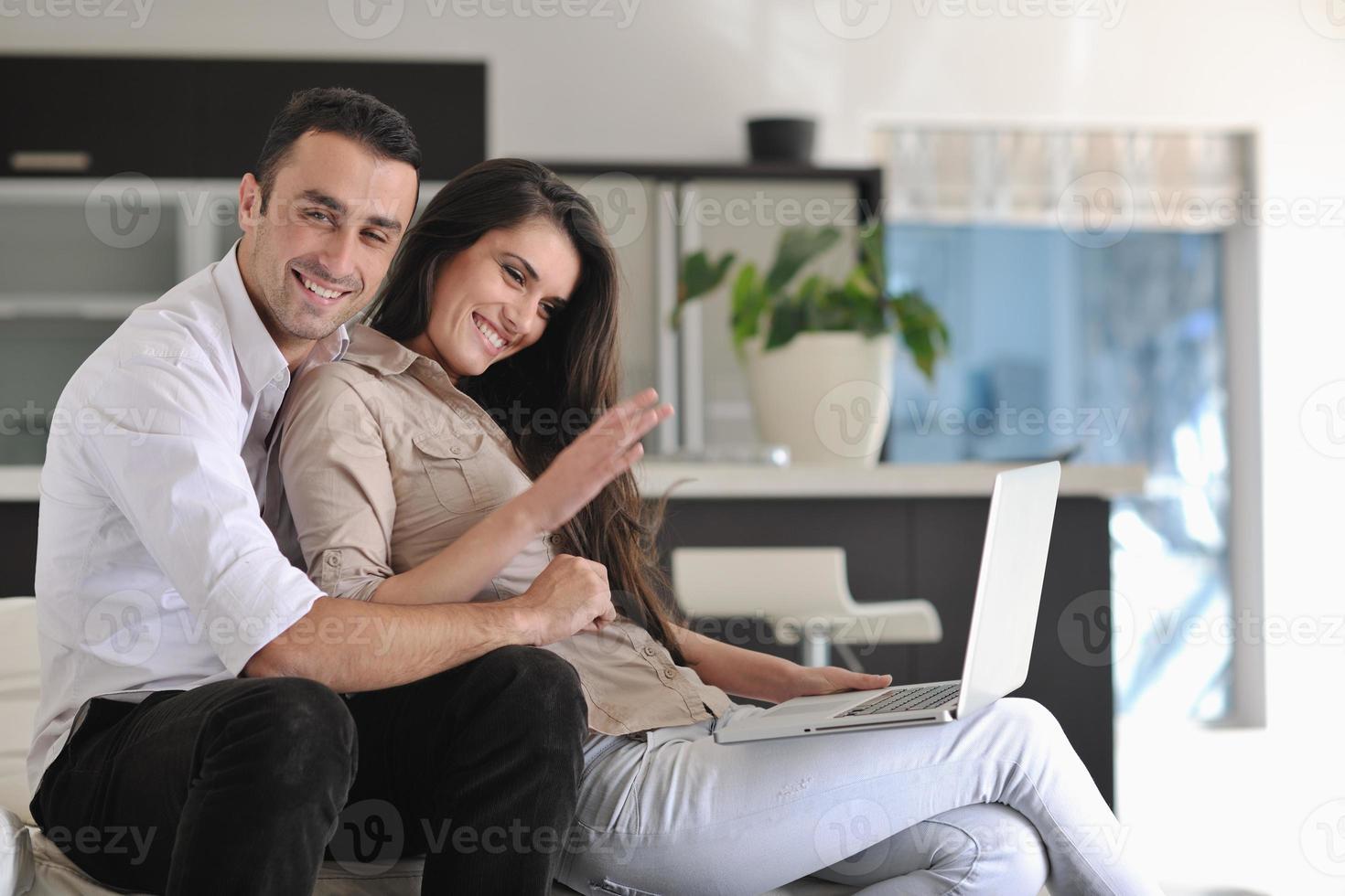 joyful couple relax and work on laptop computer at modern home photo