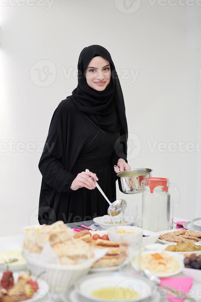 young muslim girl serving food on the table for iftar dinner photo