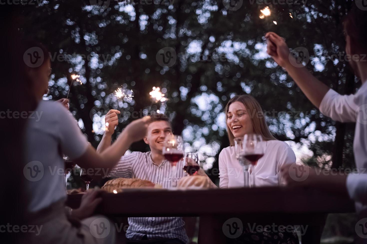 friends having picnic french dinner party outdoor during summer holiday photo