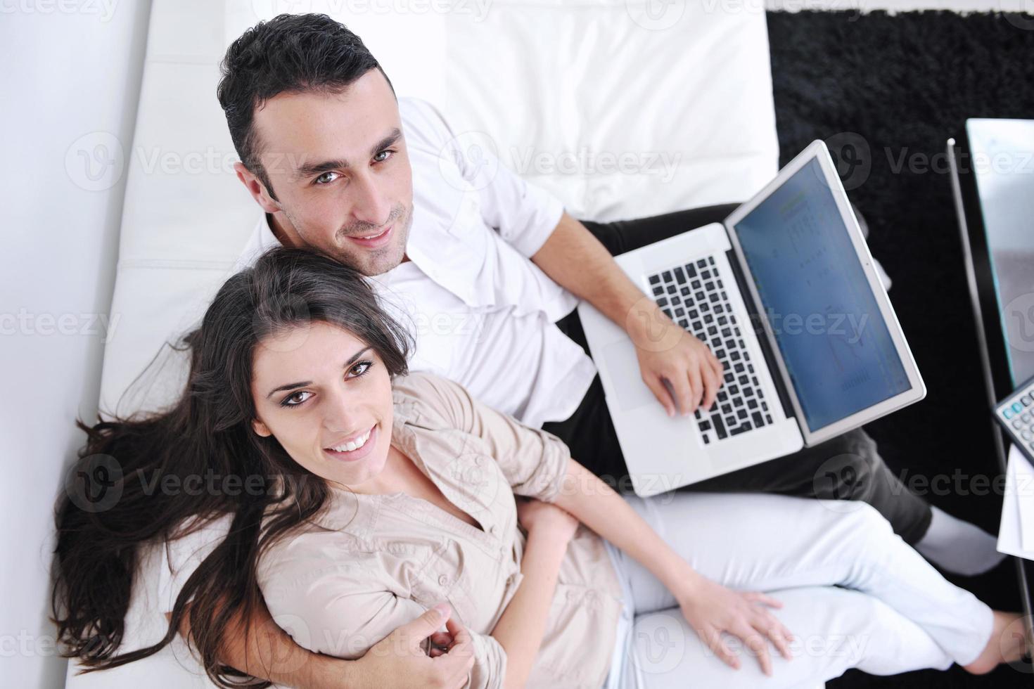 joyful couple relax and work on laptop computer at modern home photo