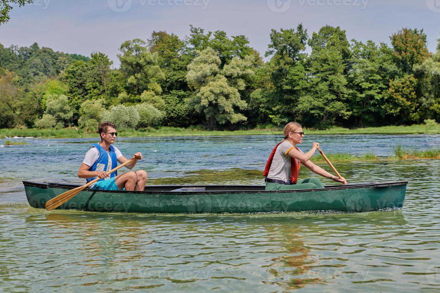 friends are canoeing in a wild river photo