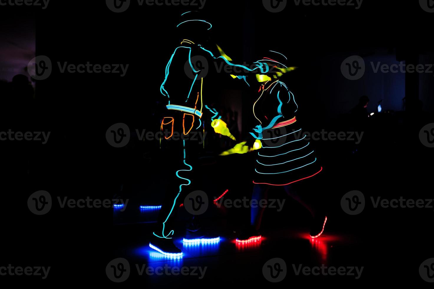 Professional barman and led light show. Silhouette of modern bartender shaking drink at night cocktail bar. photo