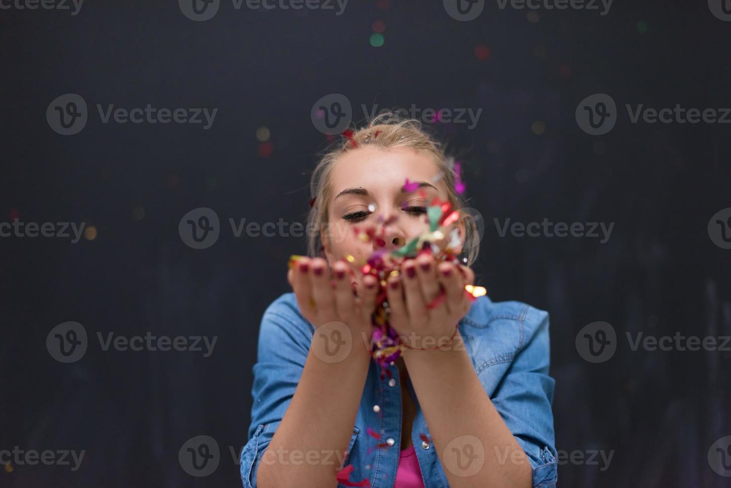 woman blowing confetti in the air photo