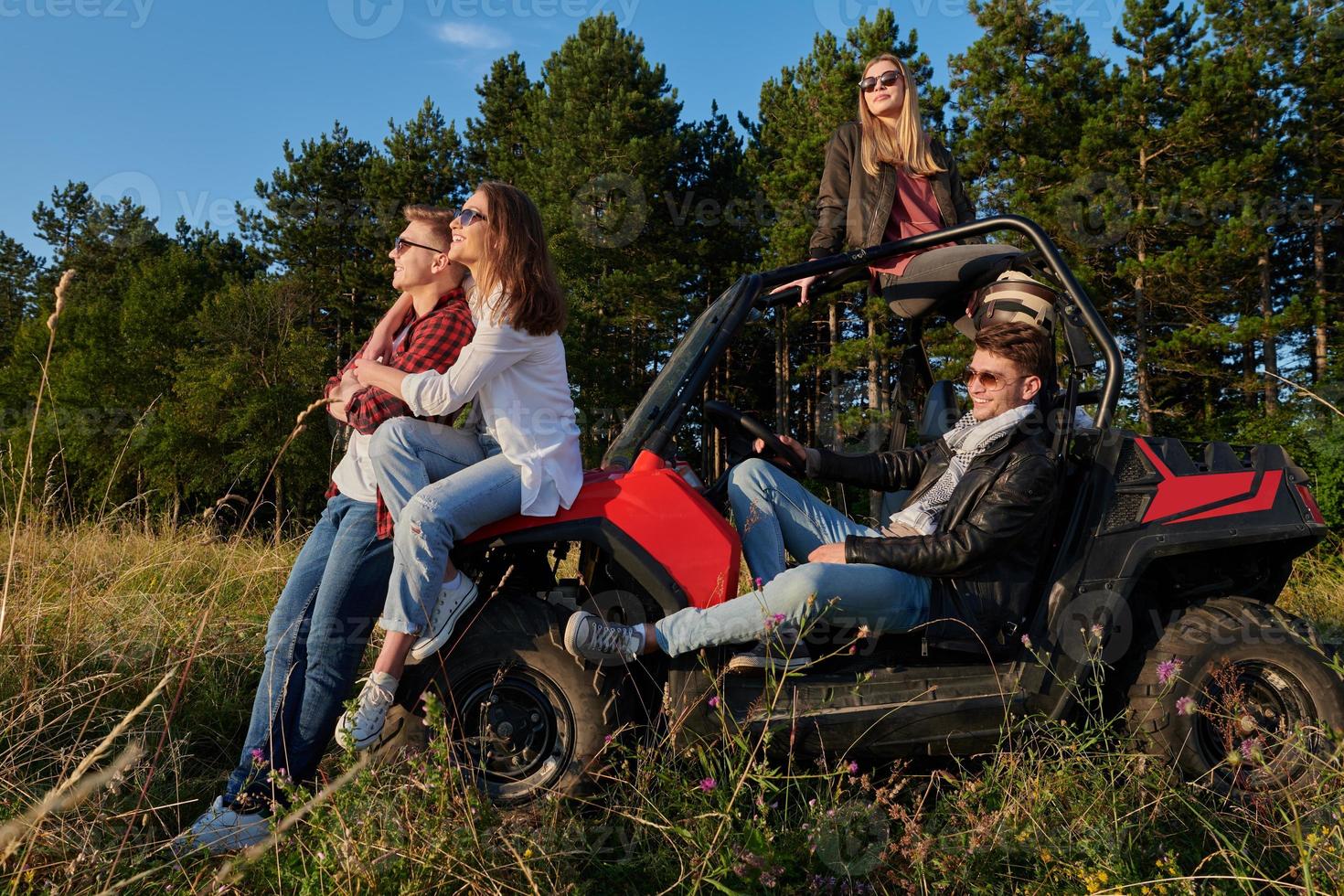group young happy people enjoying beautiful sunny day while driving a off road buggy car photo