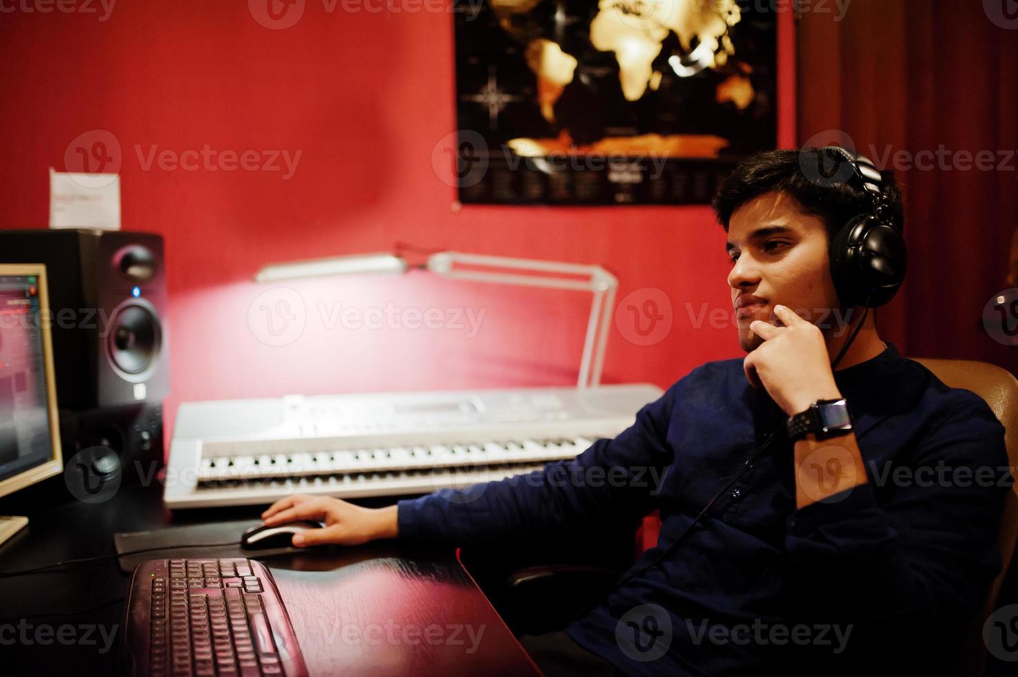 Young asian singer with microphone recording song in record music studio with sound producer. photo