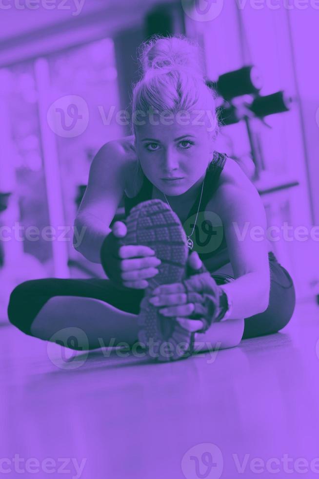 woman stretching and warming up for her training at a gym photo