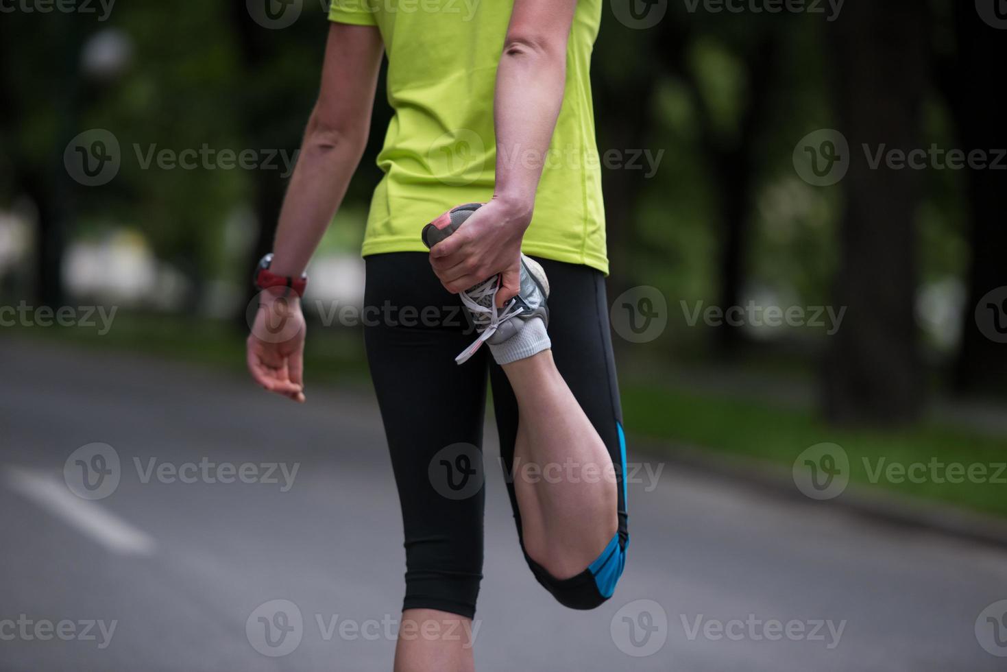 female runner warming up and stretching before morning training photo