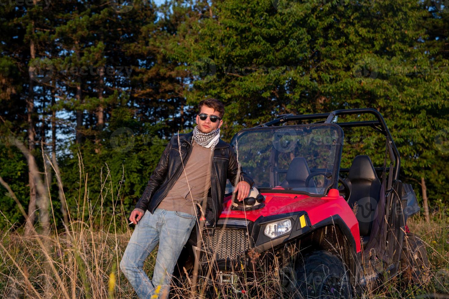 joven tomando un descanso de conducir un coche de buggy todoterreno foto