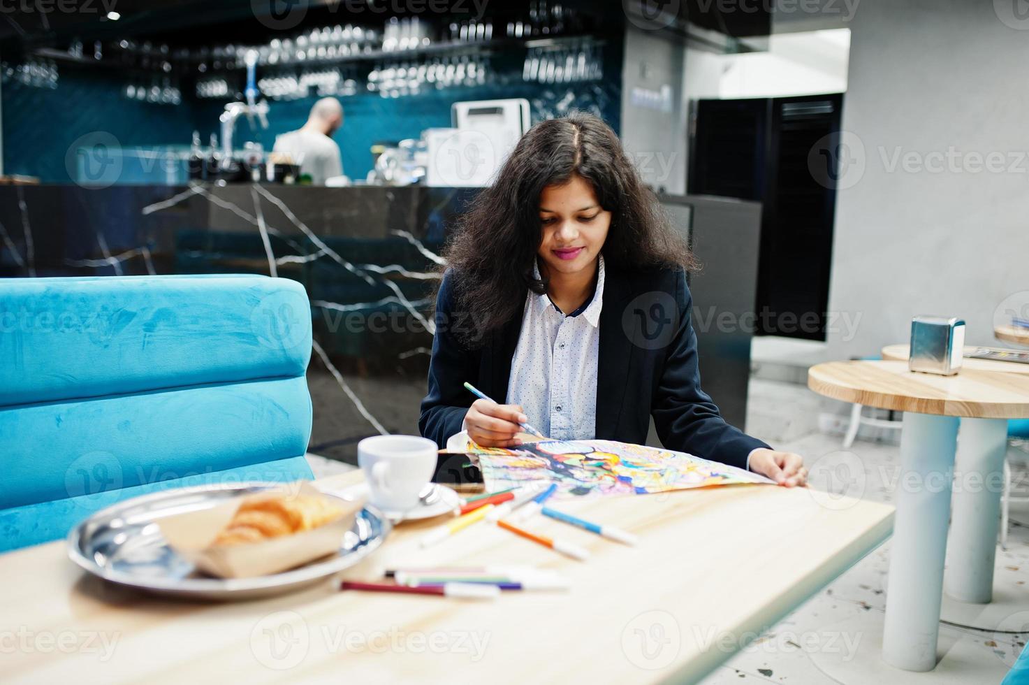 Indian artist woman wear formal paint picture, while sitting at cafe. photo