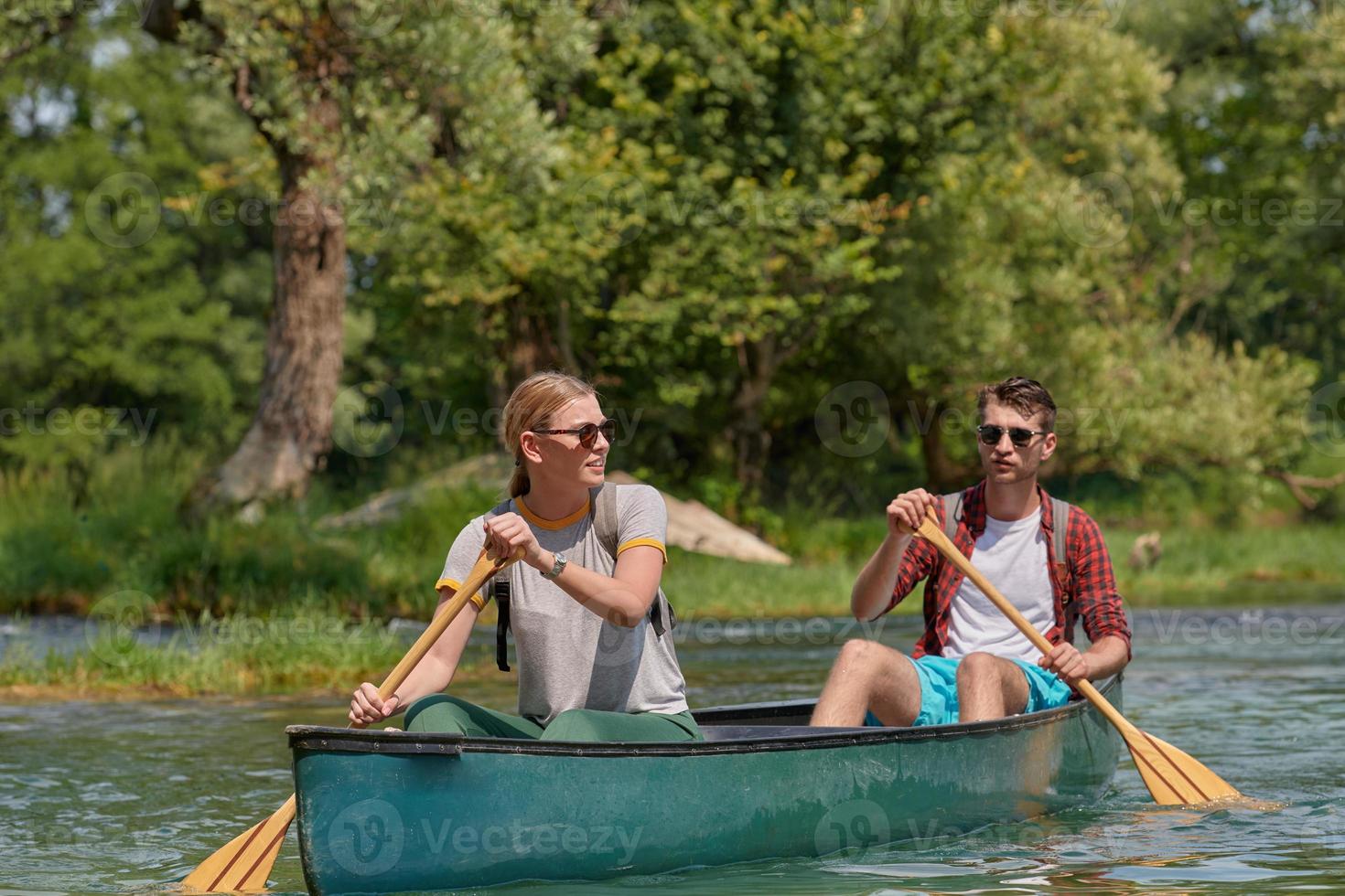 friends are canoeing in a wild river photo