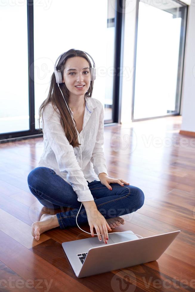 relaxed young woman at home working on laptop computer photo