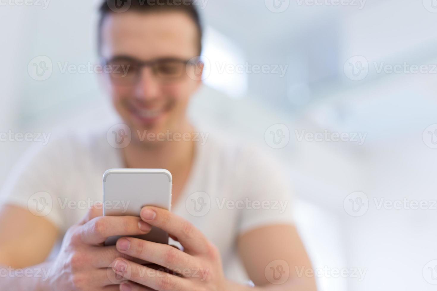 young man using a mobile phone  at home photo