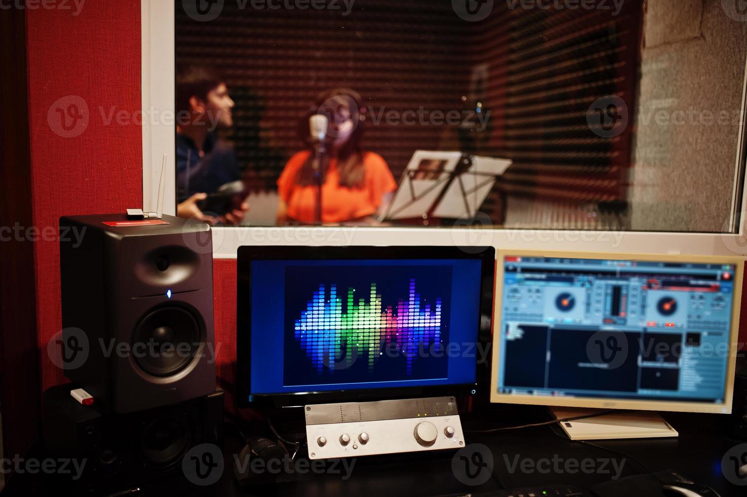 Young asian duet singers with microphone recording song in record music studio. photo