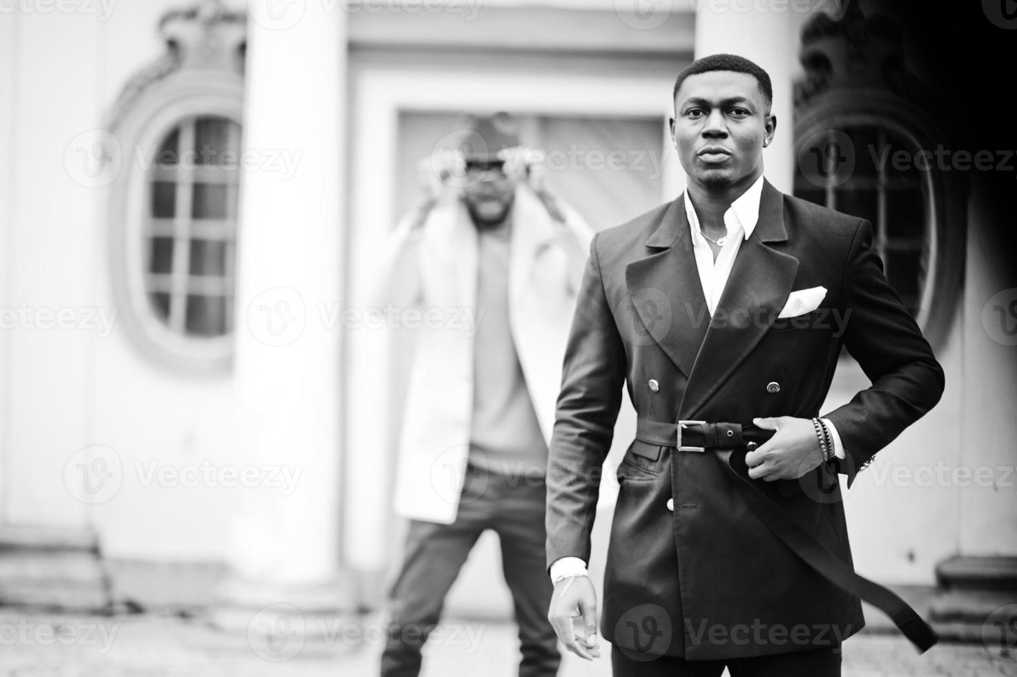 Two fashion black men. Fashionable portrait of african american male models. Wear suit, coat and hat. photo