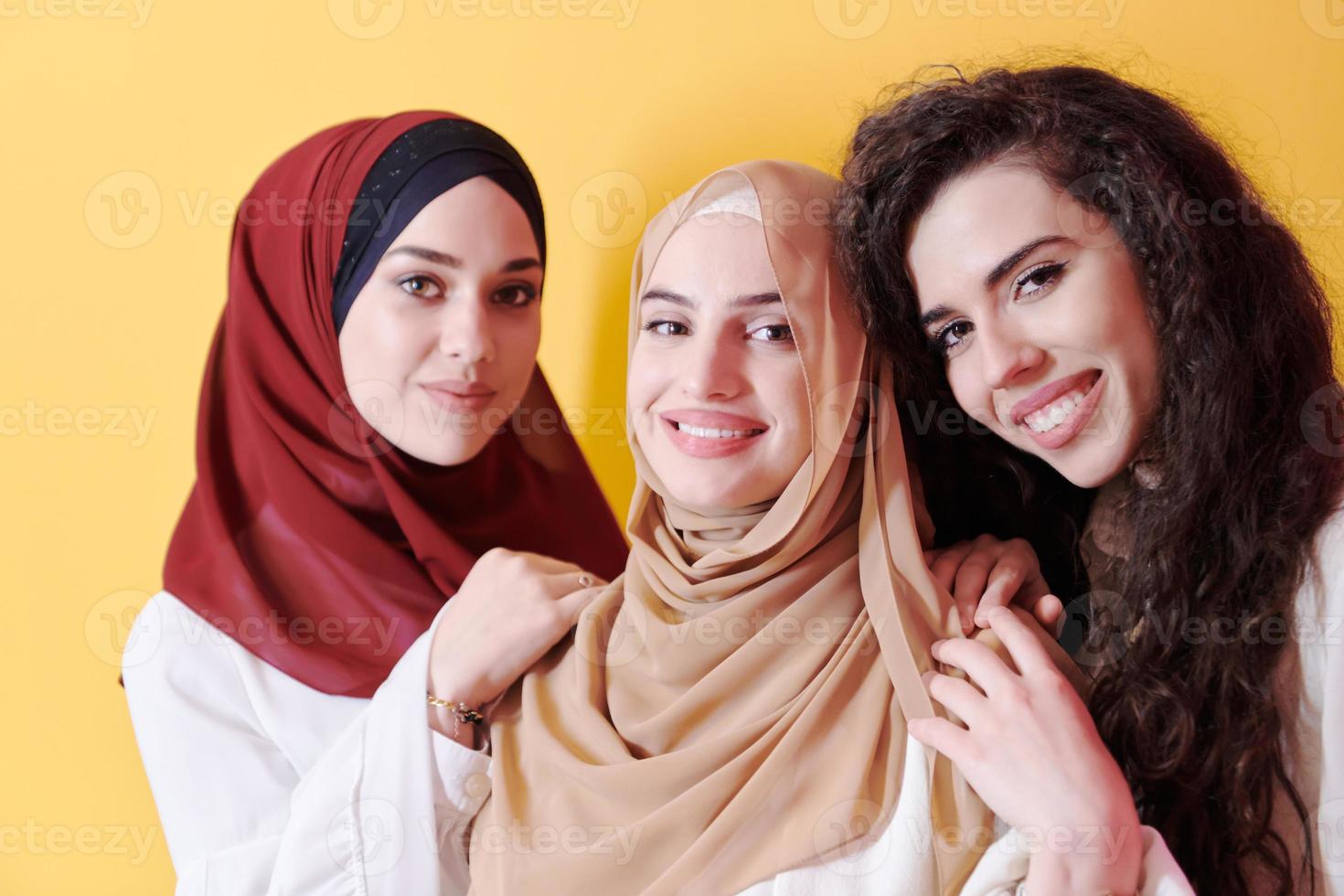 mujeres musulmanas vestidas a la moda aisladas en amarillo foto