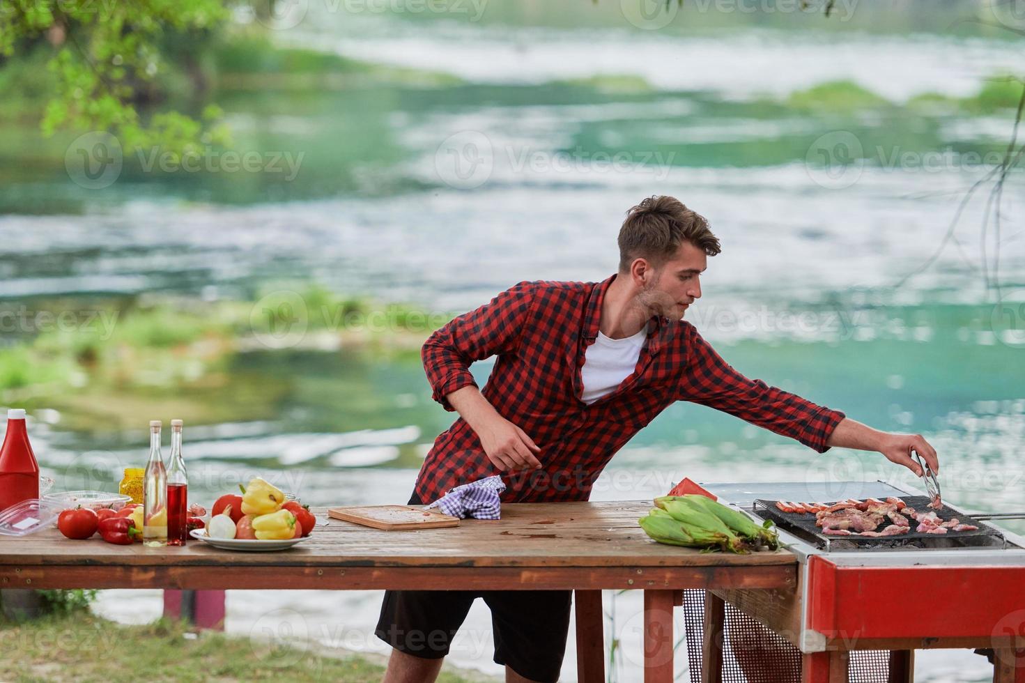 man putting spices on raw meat for barbecue photo