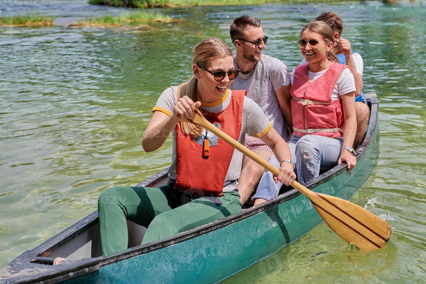 Group adventurous explorer friends are canoeing in a wild river photo