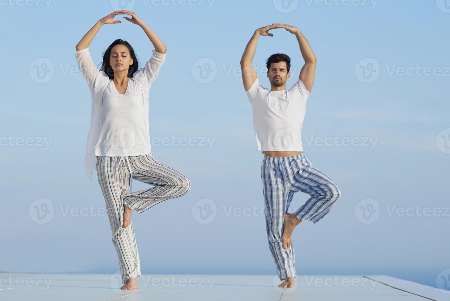 young couple practicing yoga photo
