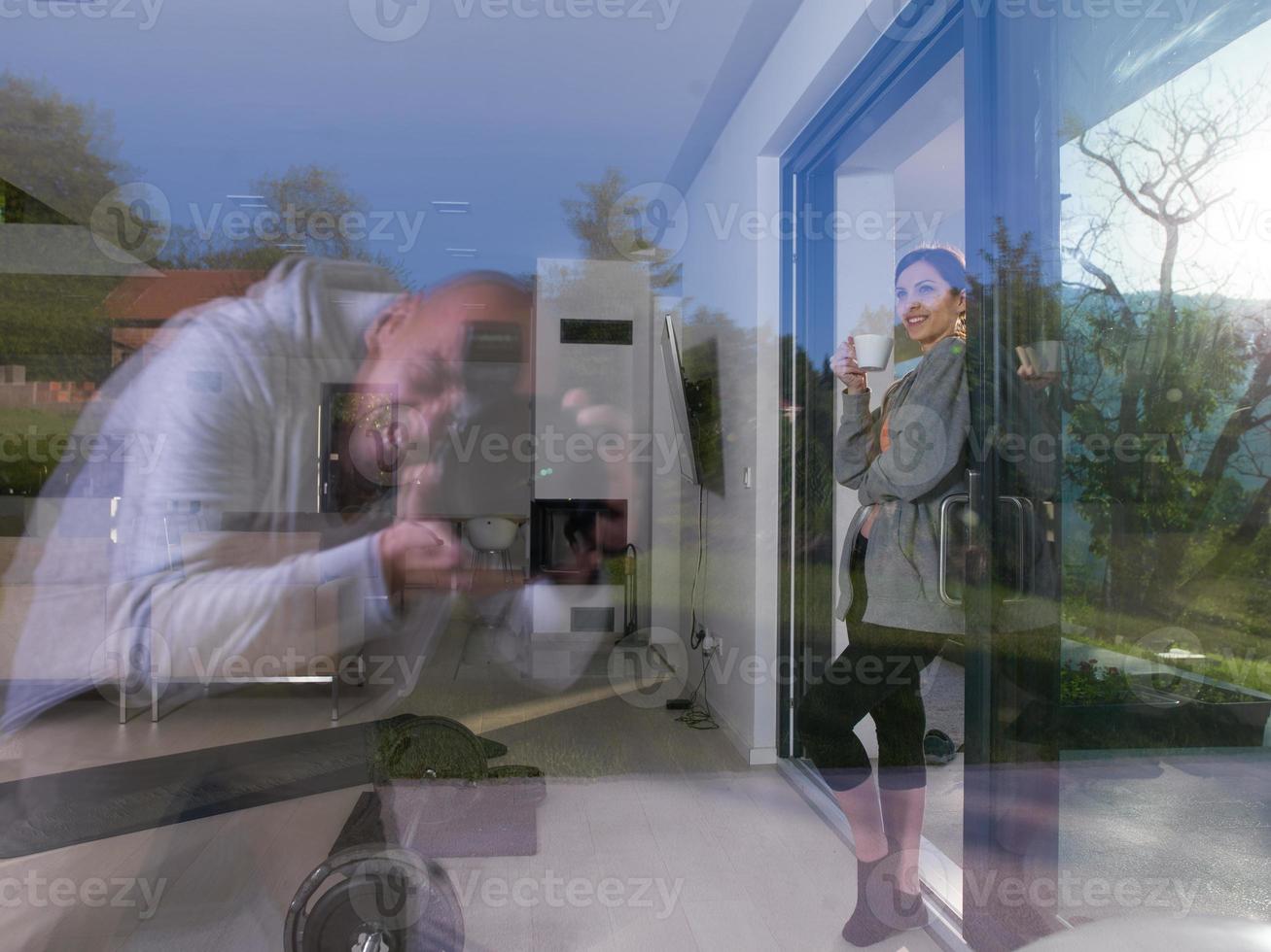 mujer tomando café frente a su villa de lujo foto