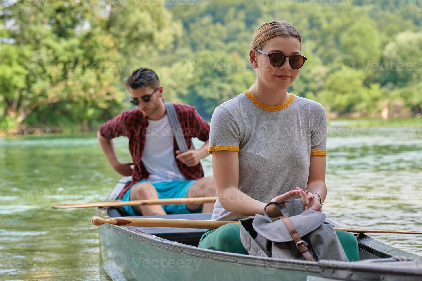 friends are canoeing in a wild river photo