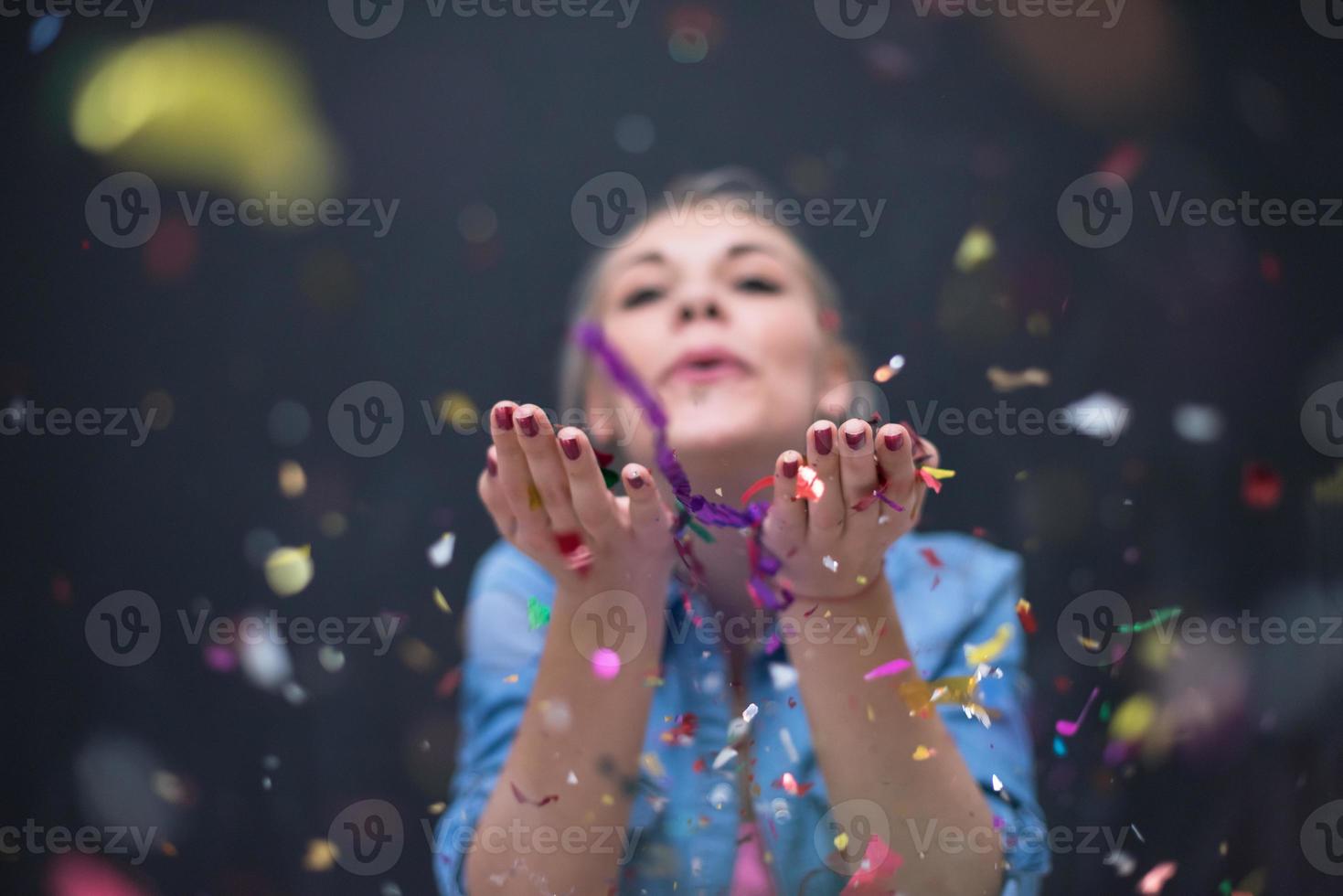 woman blowing confetti in the air photo