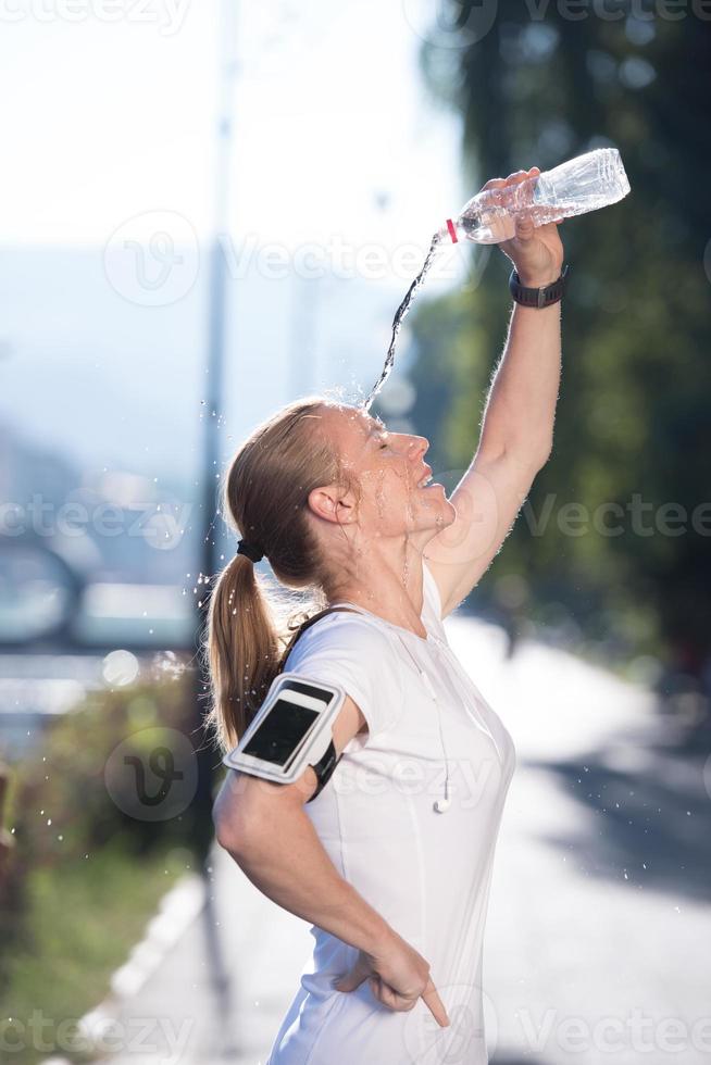 woman drinking  water after  jogging photo