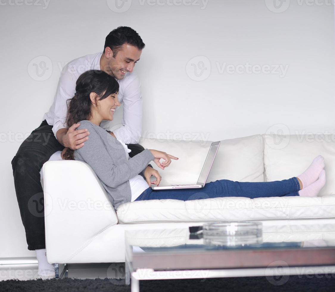 joyful couple relax and work on laptop computer at modern home photo