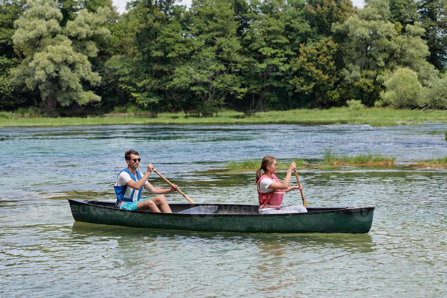 friends are canoeing in a wild river photo