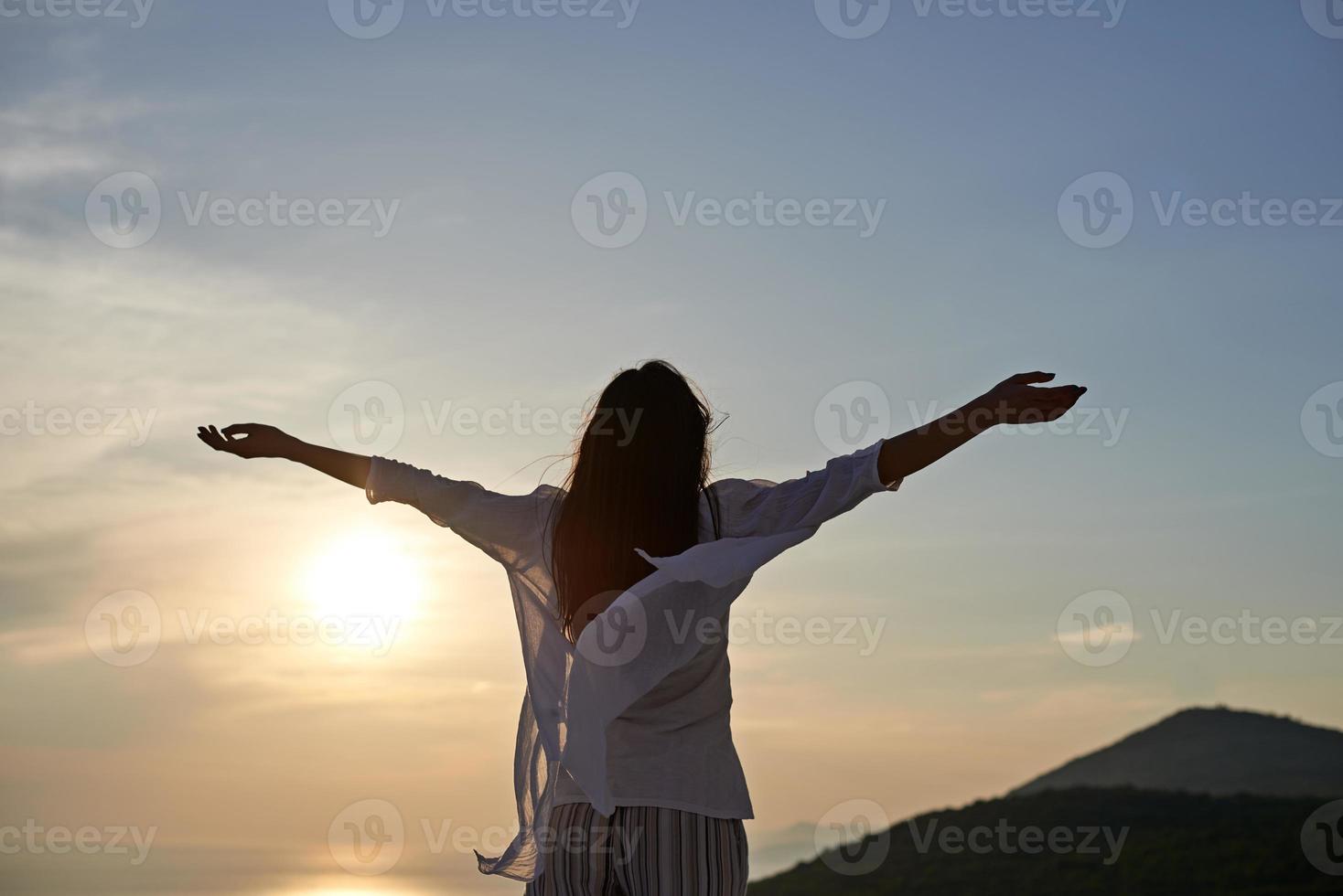 mujer joven disfruta de la puesta de sol foto