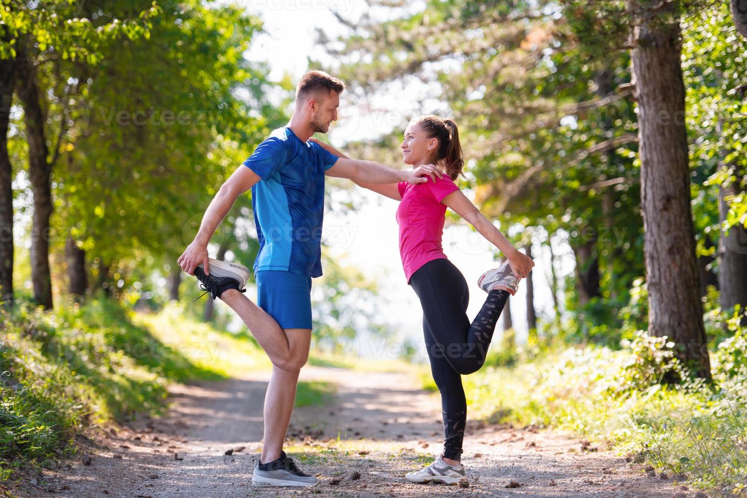 pareja joven calentándose y estirándose en un día soleado en la naturaleza foto