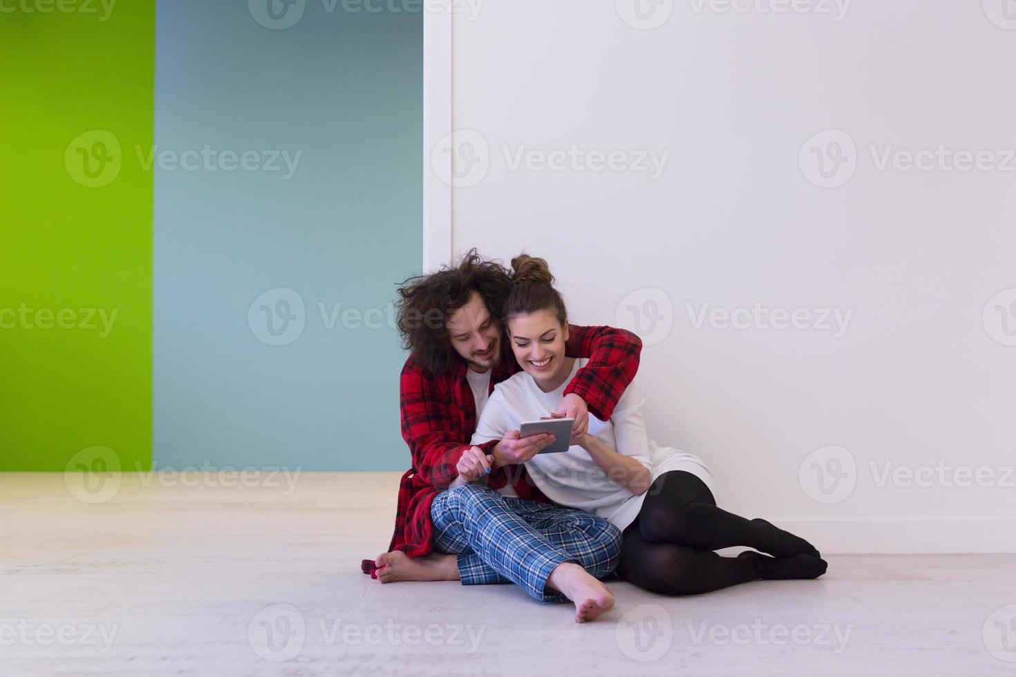 pareja joven usando tableta digital en el piso foto