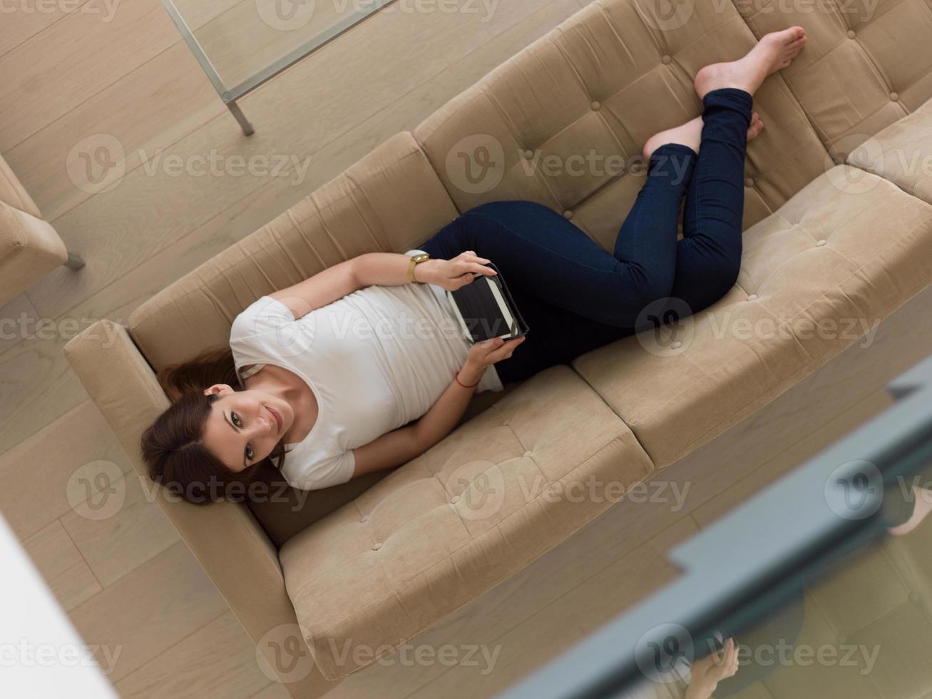 mujer en el sofá usando una computadora de tableta foto