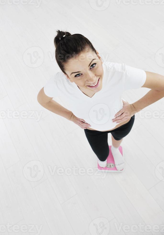 happy diet concept with young woman on pink scale photo