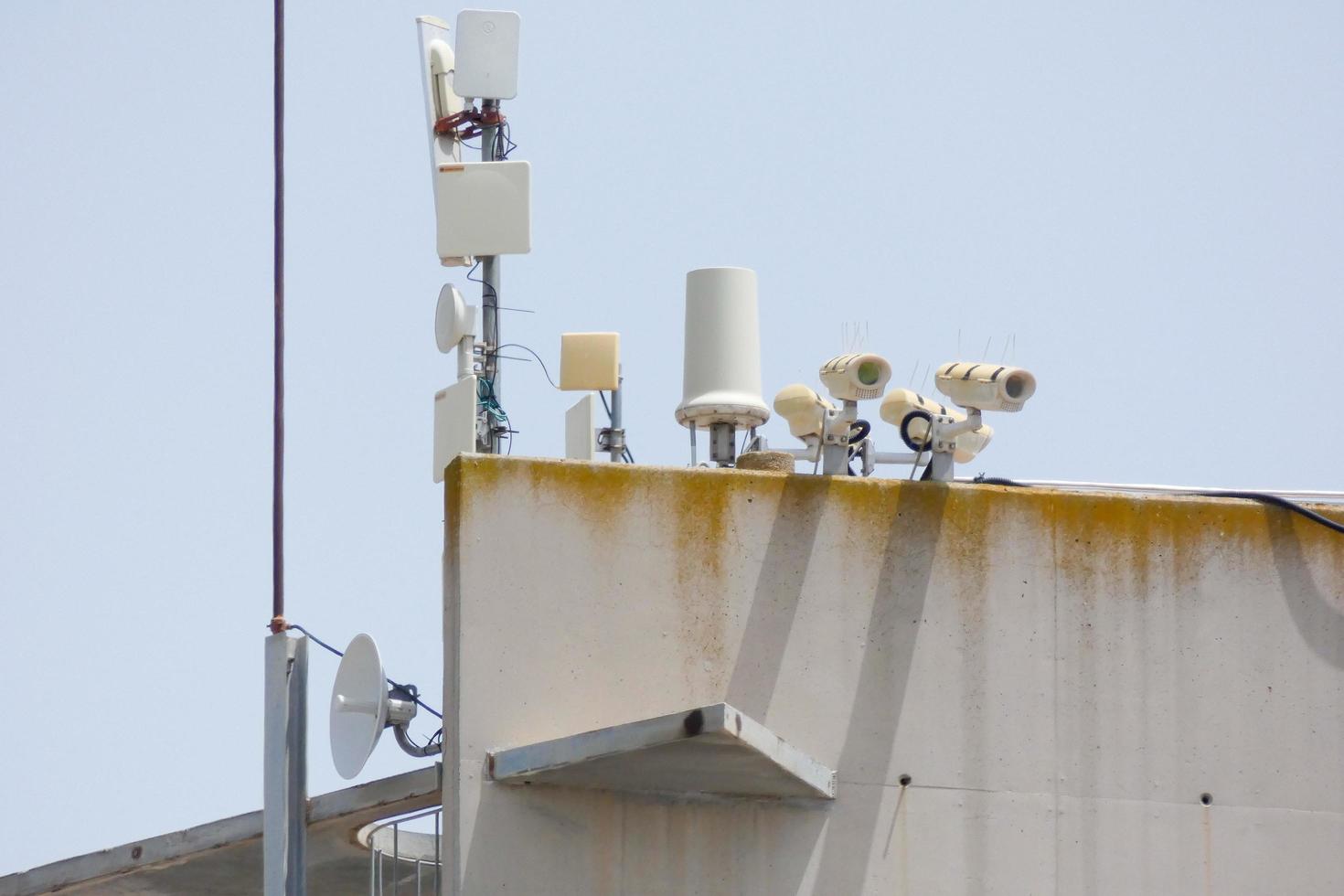 security cameras and telephone and radio antennas photo