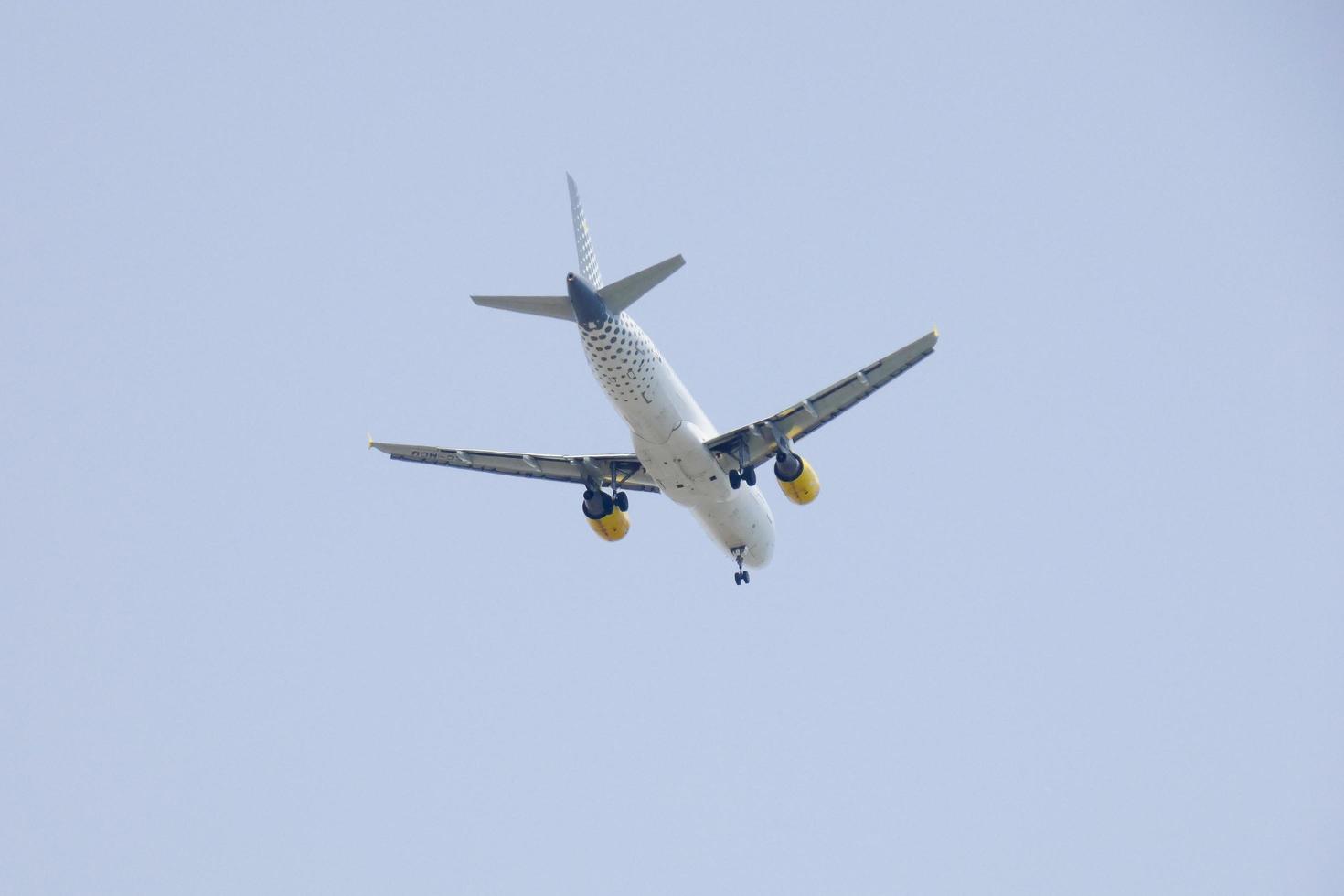 commercial aircraft flying under blue skies and arriving at the airport photo