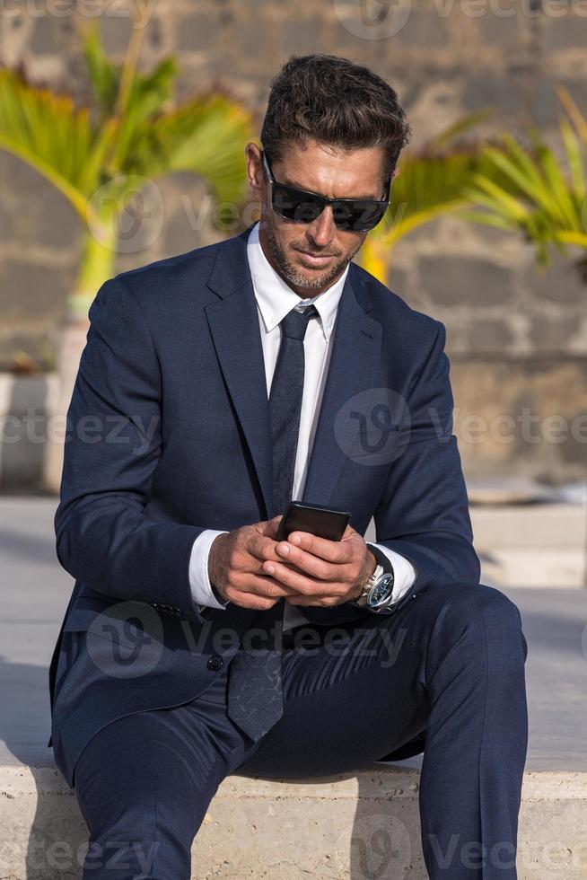 Businessman using smartphone on street photo