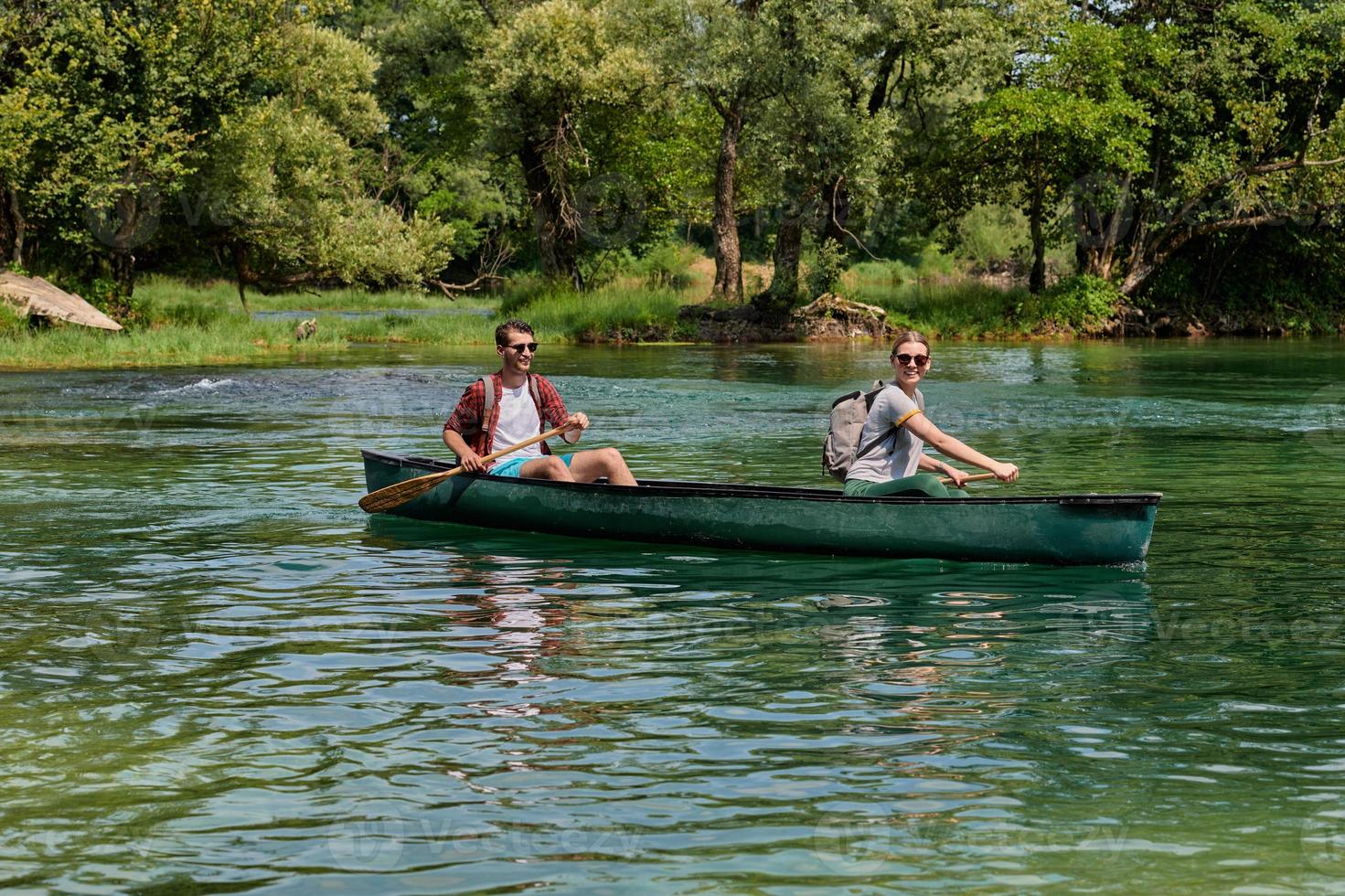 friends are canoeing in a wild river photo