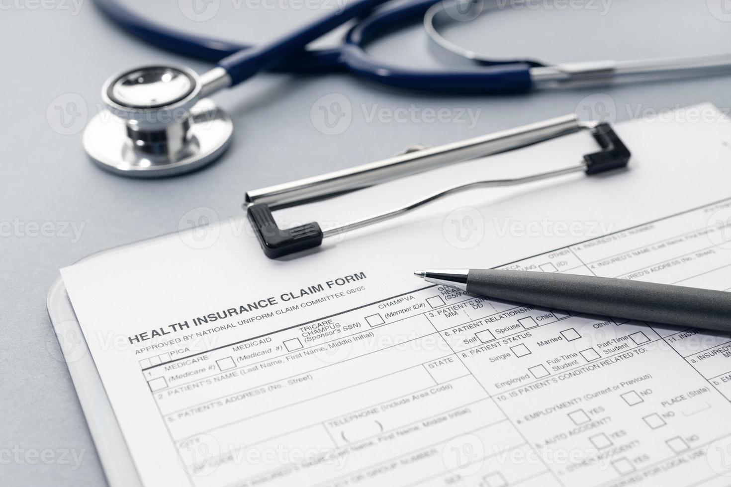 Health Insurance claim form and stethoscope on desk photo