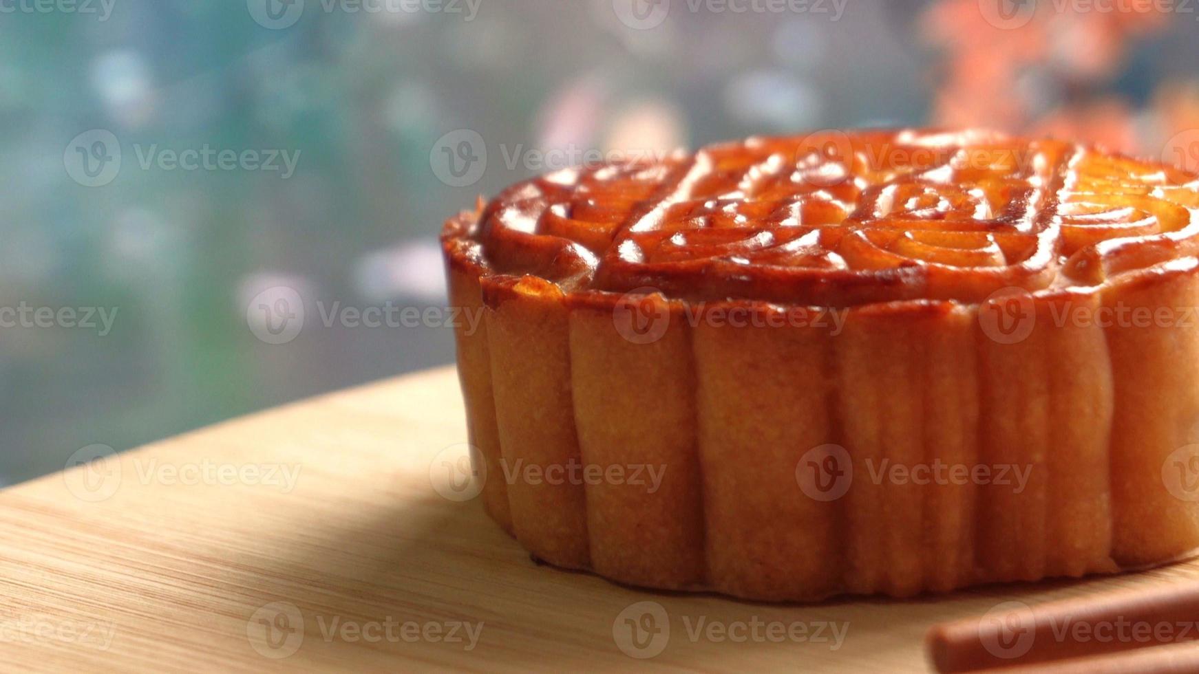 Mooncake on wooden platter board with river background. Traditional Mid-autumn Festival celebration Chinese food. photo