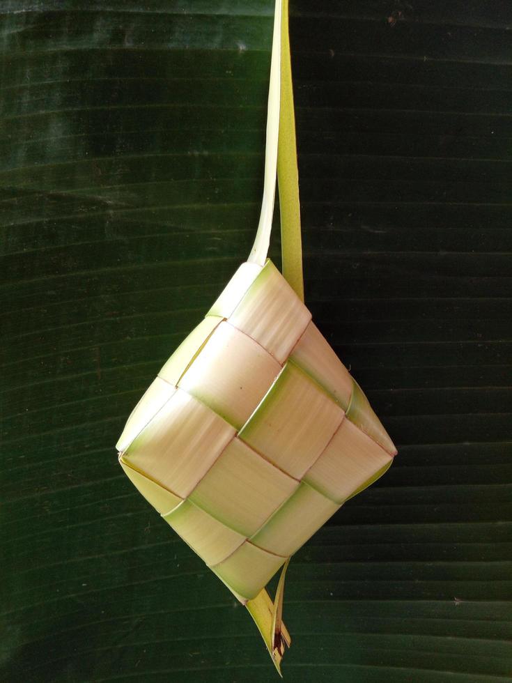 Isolated. Empty ketupat has not been filled with rice. In Indonesia, it often appears before the celebration of Eid al-Fitr after Ramadan. design concept, dark green background. photo