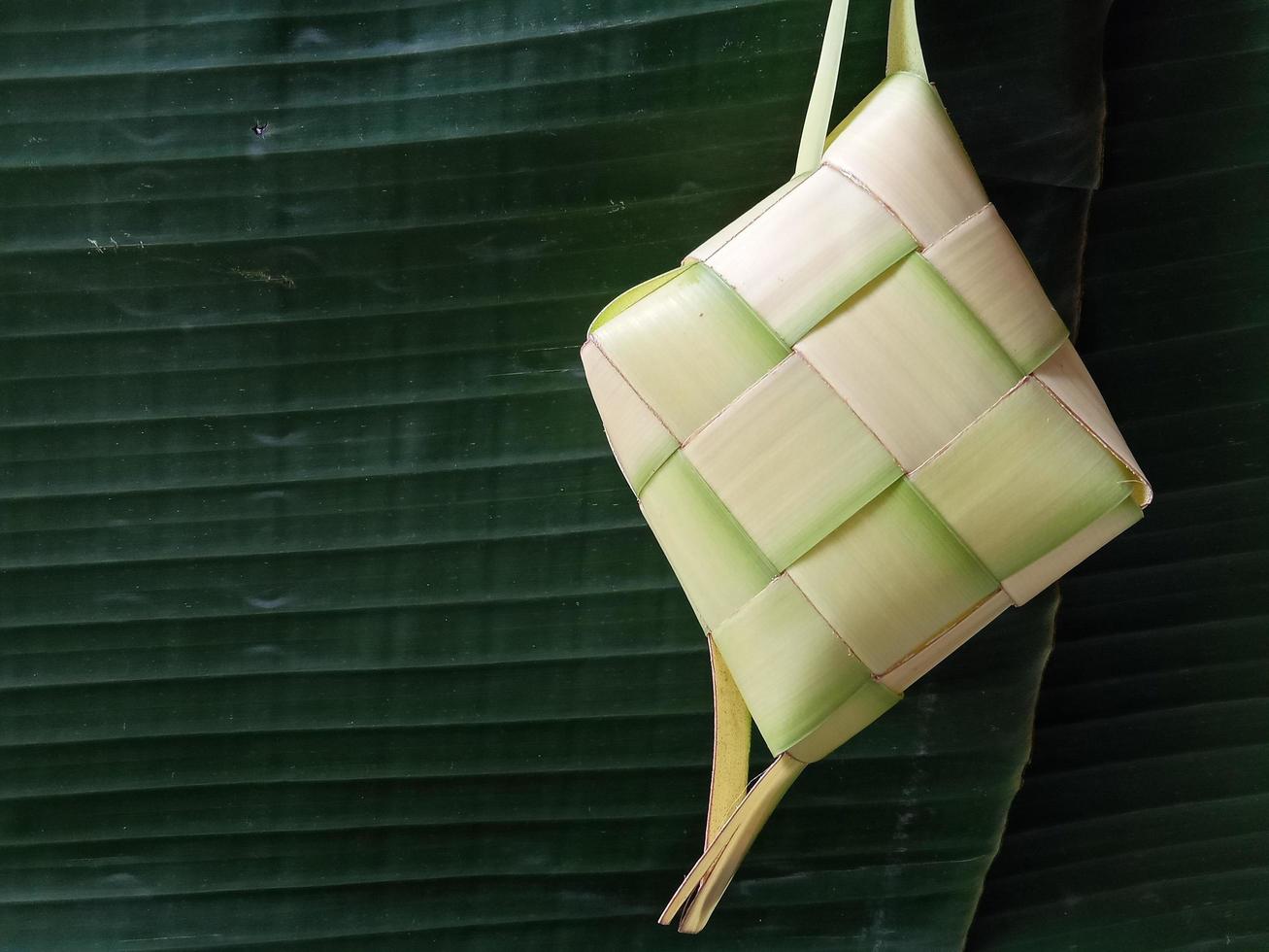 Isolated. Empty ketupat has not been filled with rice. In Indonesia, it often appears before the celebration of Eid al-Fitr after Ramadan. design concept, dark green background. photo